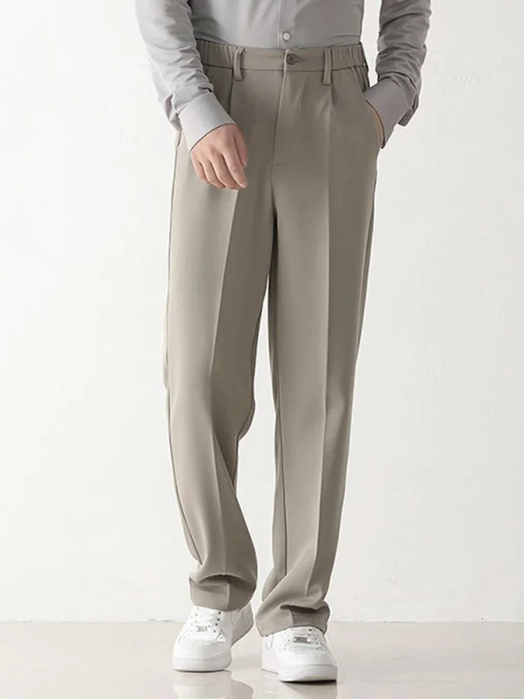 Black polyester blend men's chino trousers, relaxed fit, offering draped comfort & business casual style.