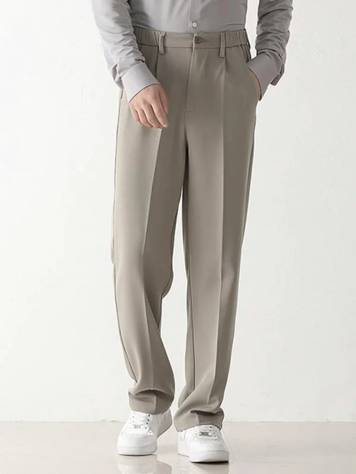 Black polyester blend men's chino trousers, relaxed fit, offering draped comfort & business casual style.
