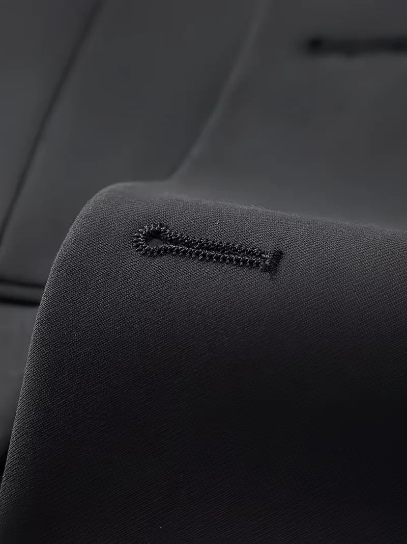 Detail view of men's black slim fit suit, highlighting double-breasted waistcoat.