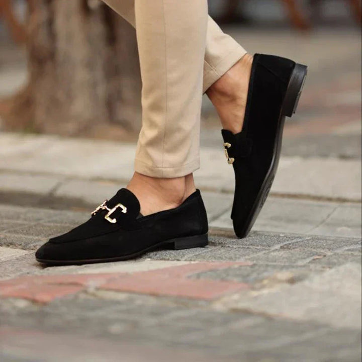 Smart men's slip-on loafers with a polished metal buckle, perfect footwear for professional and casual settings.