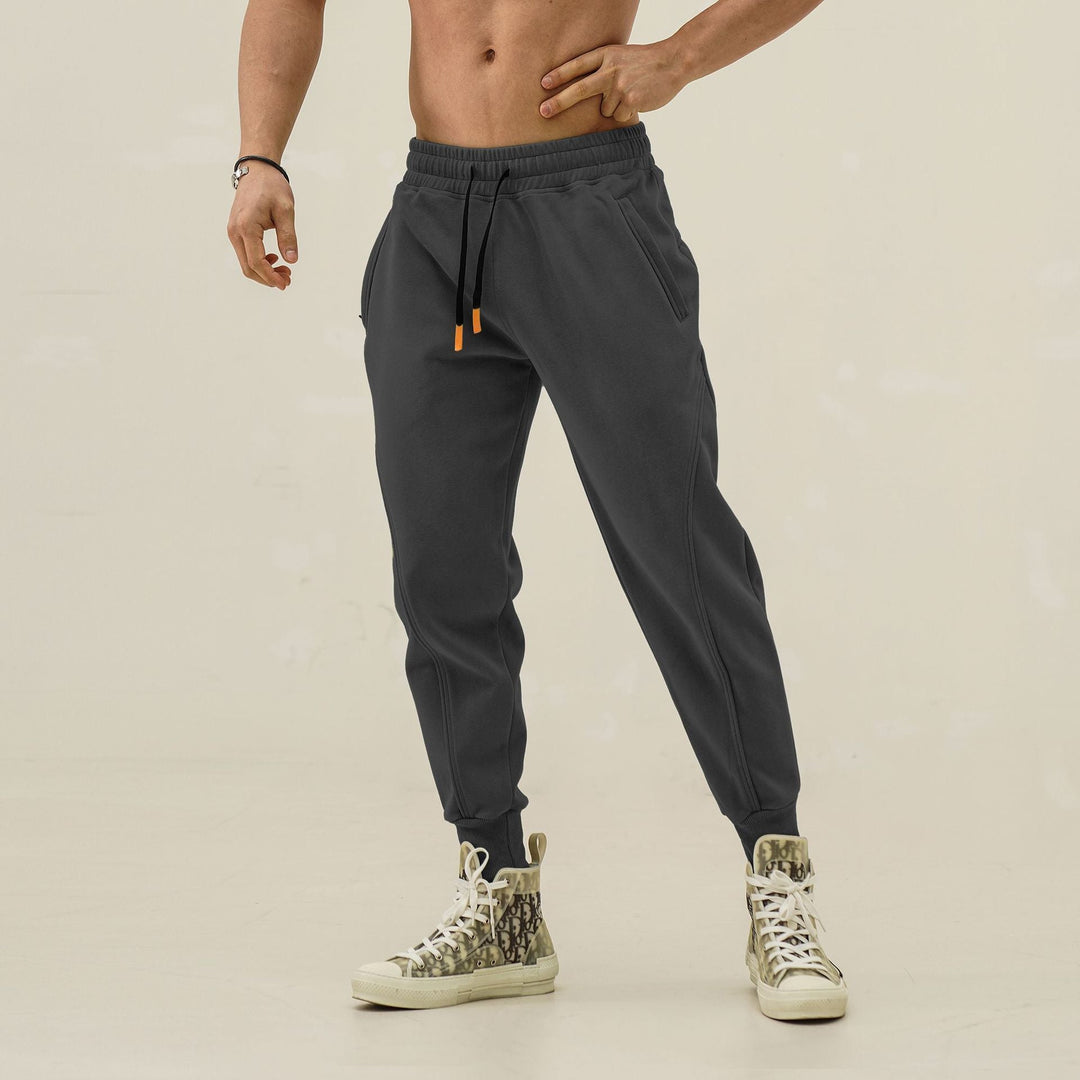 Black men's activewear joggers, elastic waist, cool side stripes. Perfect for running & daily wear.