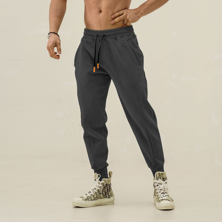 Black men's activewear joggers, elastic waist, cool side stripes. Perfect for running & daily wear.