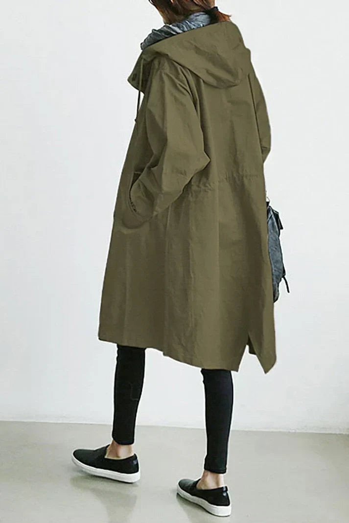 Man wearing a long waterproof trench coat with hood, showcasing its stylish fit and weather protection.