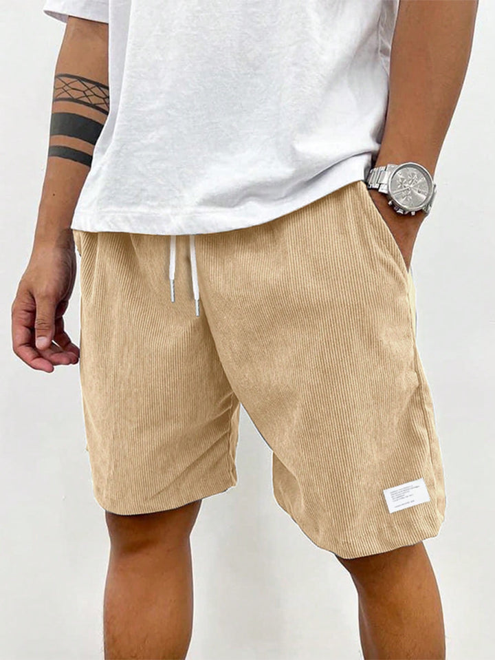 Close-up of ribbed texture on men's casual shorts with drawstring. Emphasizes fabric comfort and quality.