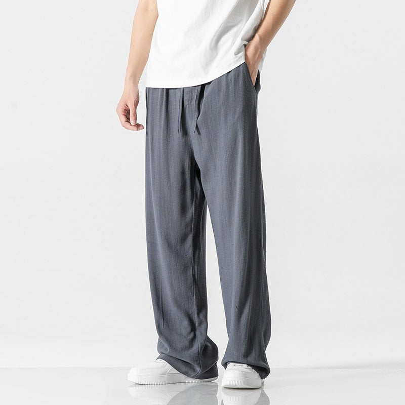 Men's relaxed fit full-length trousers with a drawstring waist, great for casual and versatile styling.