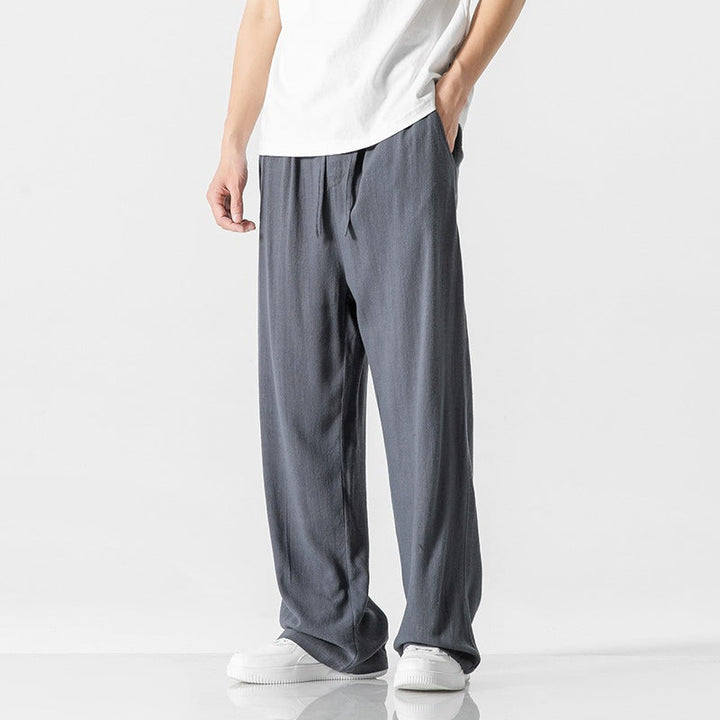Men's relaxed fit full-length trousers with a drawstring waist, great for casual and versatile styling.