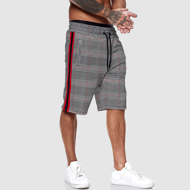 Man wearing knee-length plaid shorts, showcasing their casual style & comfortable relaxed fit for summer.
