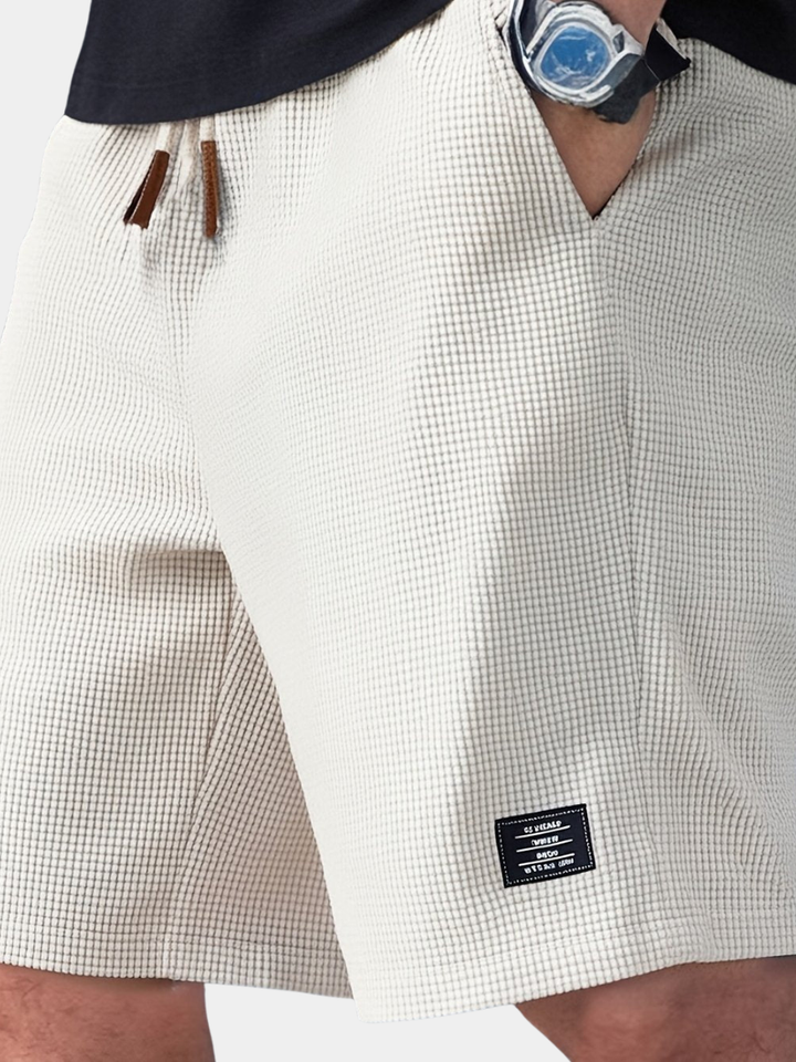 Detail shot: Elastic waistband & drawstring on men's casual summer shorts, ensuring comfortable everyday fit.