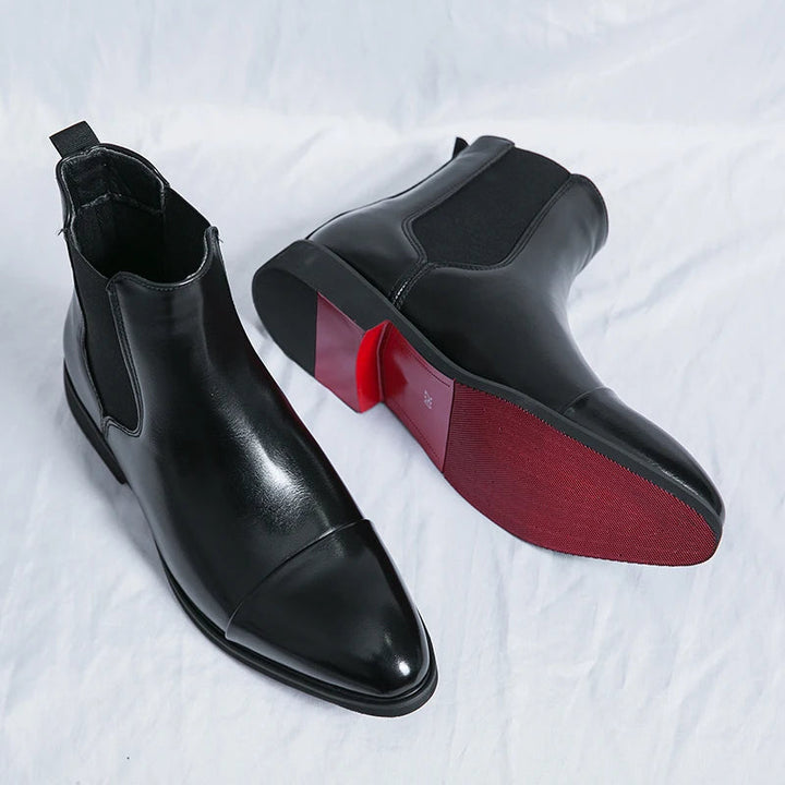 Black men's slip-on Chelsea ankle boots featuring a refined cap toe. Ideal dress boots for contemporary men's fashion.