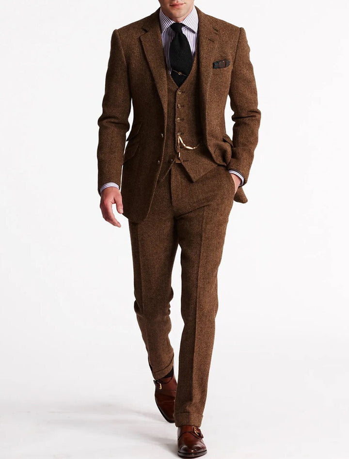 Detailed view of brown herringbone fabric on a men's three piece suit.
