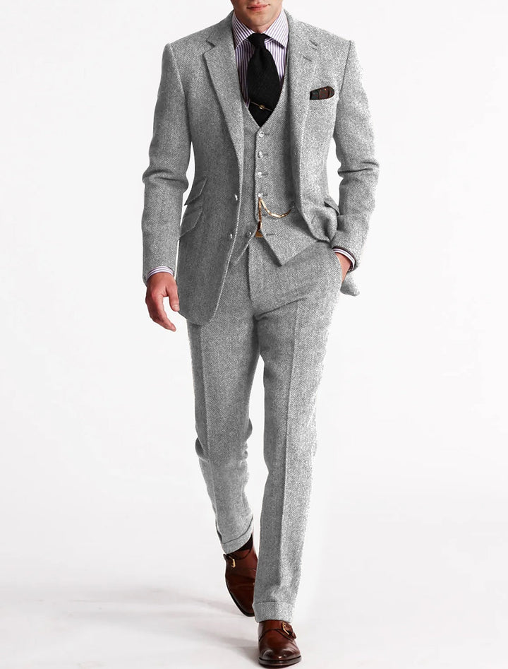 Model wearing a fashionable men's brown herringbone three piece suit for a wedding.