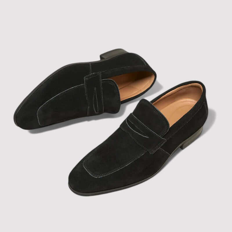 Side profile of men's sleek black penny loafers, highlighting the comfortable sole and classic silhouette. Versatile men's shoes.