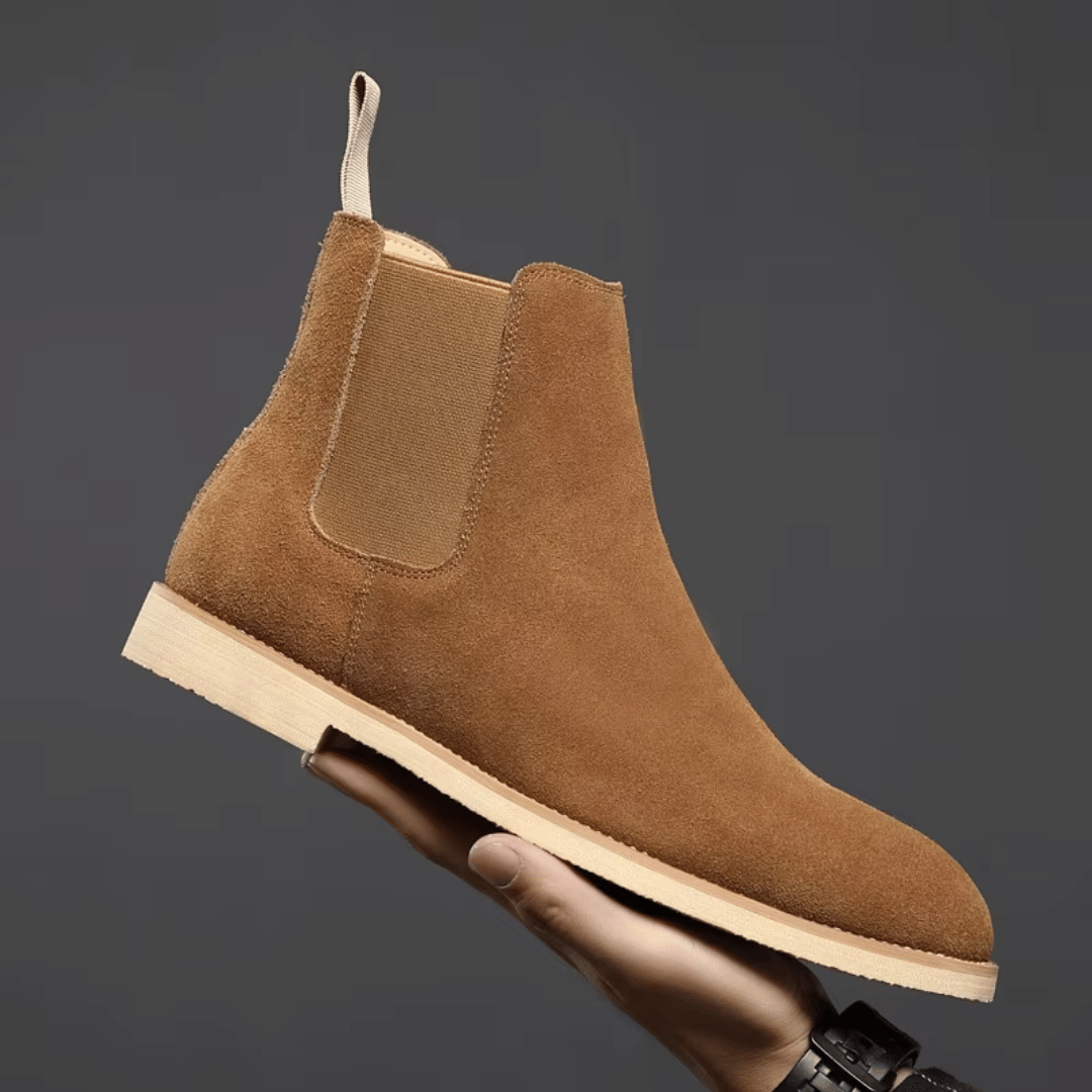 Close-up of men's dark grey suede ankle boots, showing texture and stitching detail.