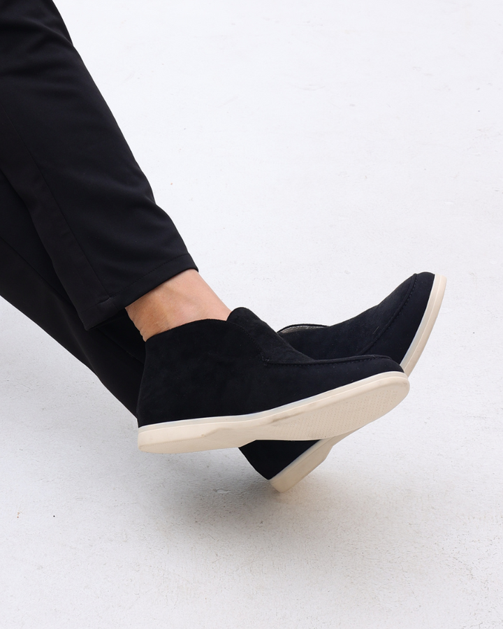 Side view of a man's black suede loafer, showcasing classic slip-on design.