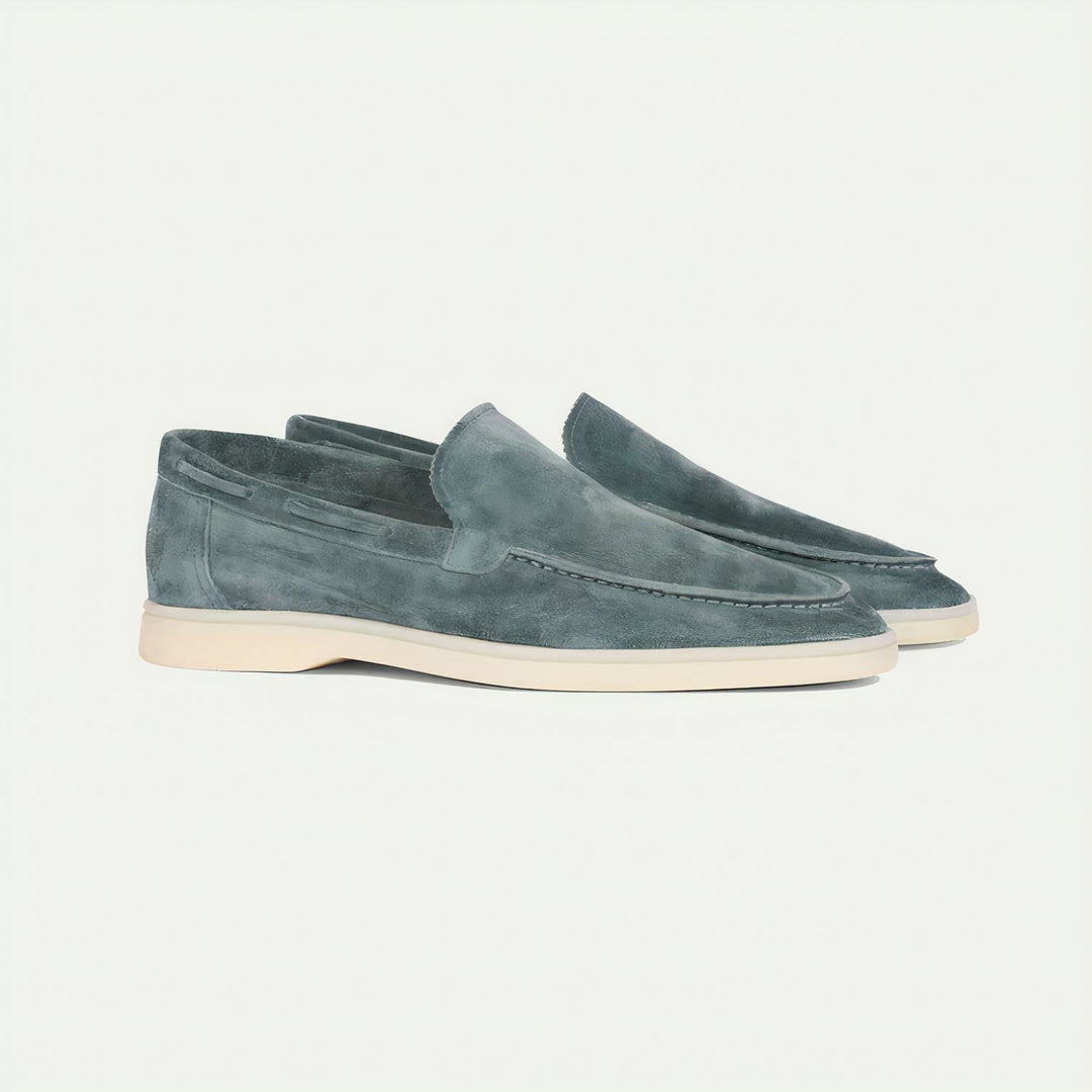 Side profile of men's grey suede loafers, highlighting the smooth texture and slip-on design