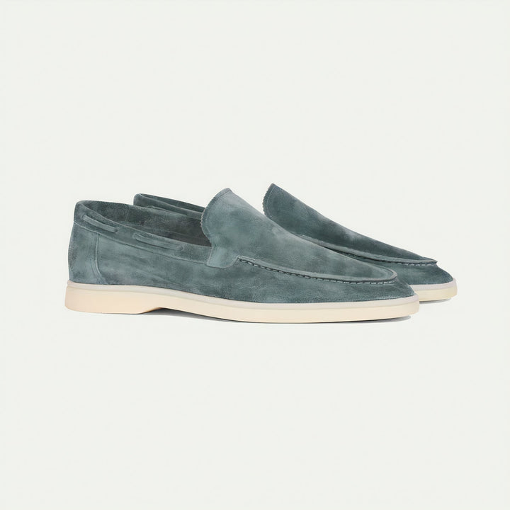 Side profile of men's grey suede loafers, highlighting the smooth texture and slip-on design