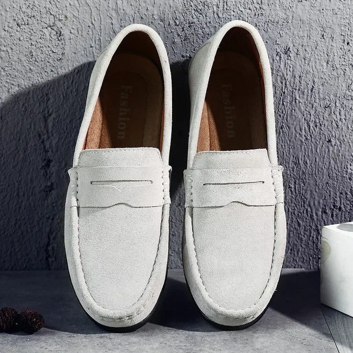 Stylish men's navy blue suede slip-on loafers, perfect for smart casual outfits.