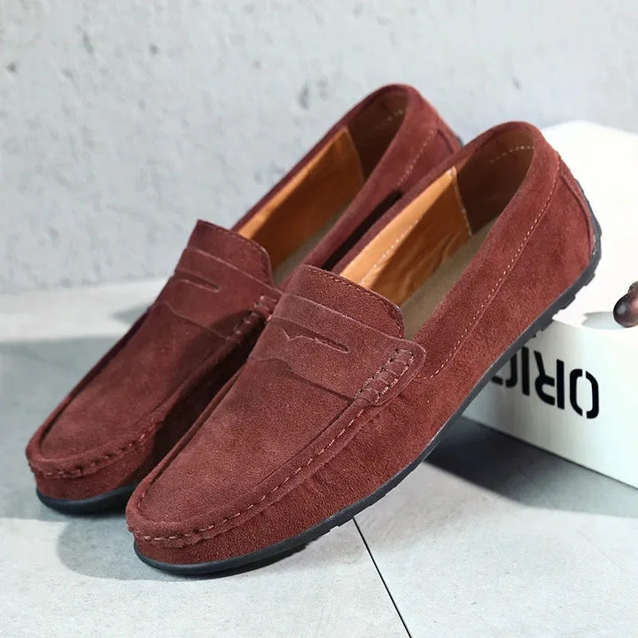 A pair of men's rich burgundy suede penny loafers, offering a touch of sophistication.