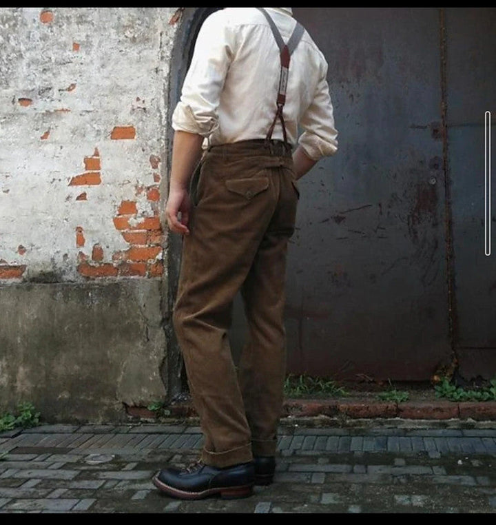 Smart casual brown tailored trousers for men, featuring pleats and suspender buttons.