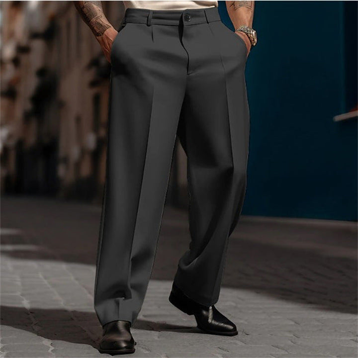 Man in classic high-waisted wide leg suit trousers, showcasing elegant drape, comfort, and versatile men's fashion.
