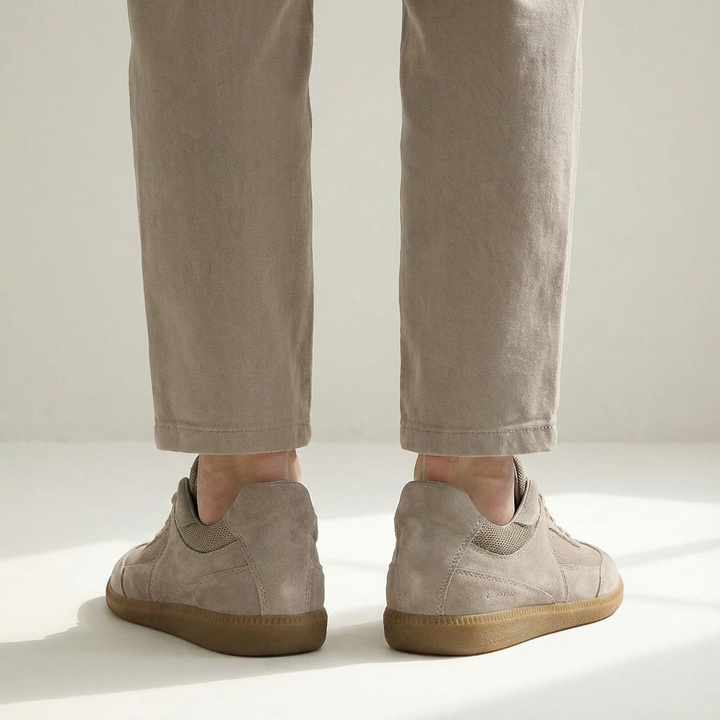 Close-up of men's low-top sneakers, highlighting the premium Italian leather and textured gum sole.