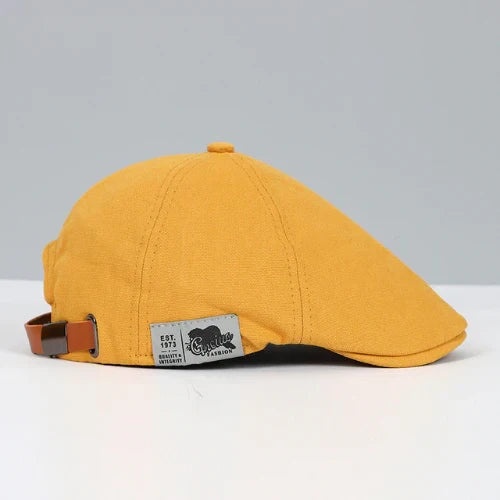 Men's casual ivy cap with a unique button top and buckled adjustable strap. Essential classic style headwear.
