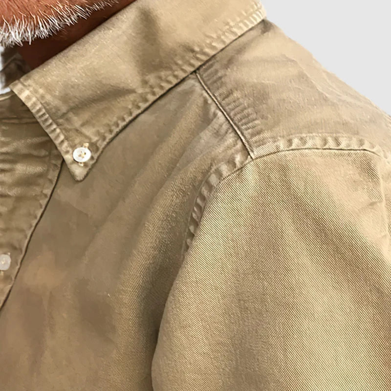 Close-up of the quality fabric on a men's classic long-sleeve button-up shirt, a wardrobe staple.