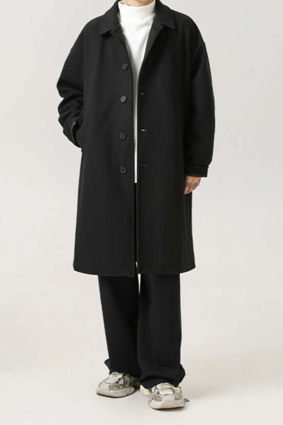 Man in a classic oversized black winter coat, showcasing timeless style, comfort, and elegant men's outerwear.