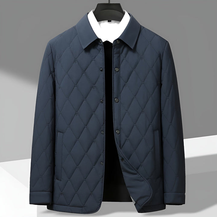Close-up of men's quilted jacket texture, showing button-down front & classic stitching. Ideal for fall fashion.