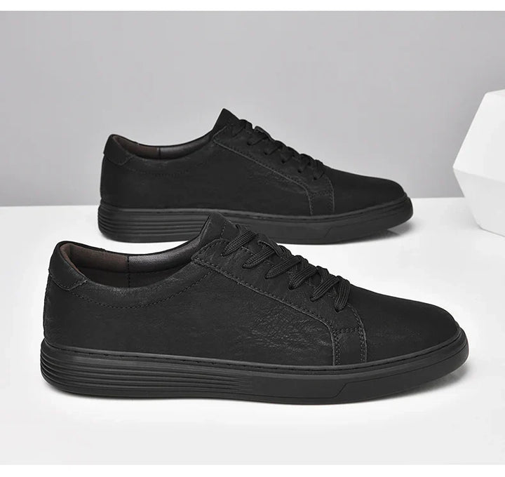 Frontal view of men's classic summer trainers, low-top and lace-up design with clear contrast stitching.