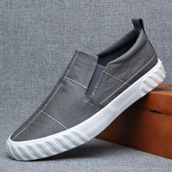 Casual men's loafers featuring easy slip-on design and prominent contrast stitching. Comfortable everyday footwear.