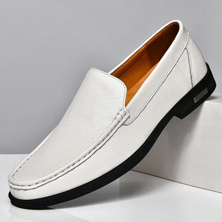 Stylish men's navy blue slip-on loafers, showcasing a sleek design for easy wear & elegant comfort.