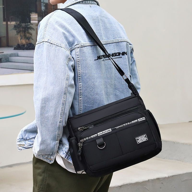 Front view of a men's messenger bag, showing multiple pockets and durable fabric.