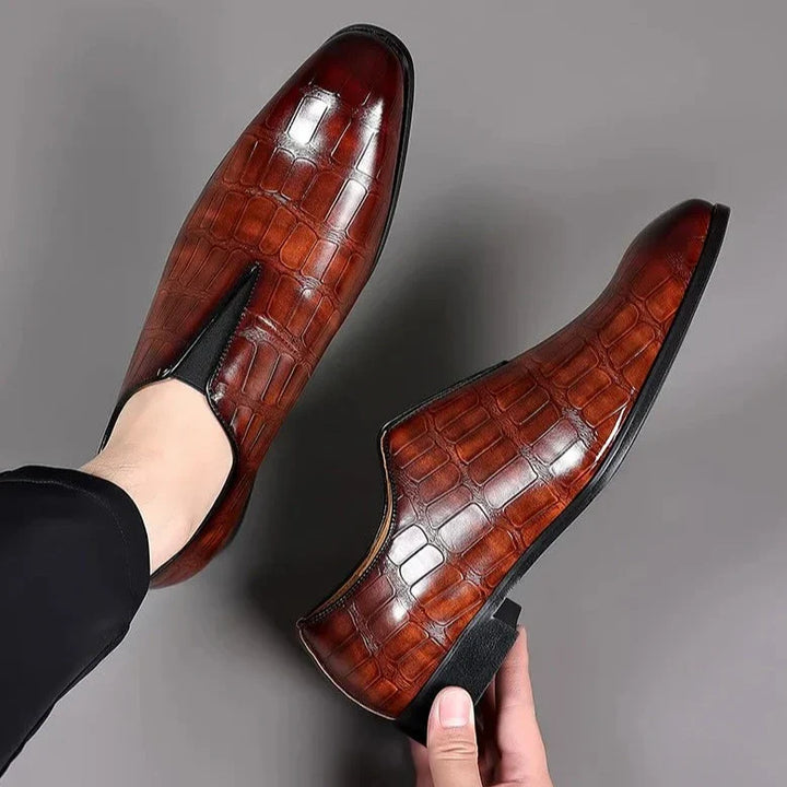 Classic men's slip-on brogue shoes with a sleek glossy crocodile pattern finish.