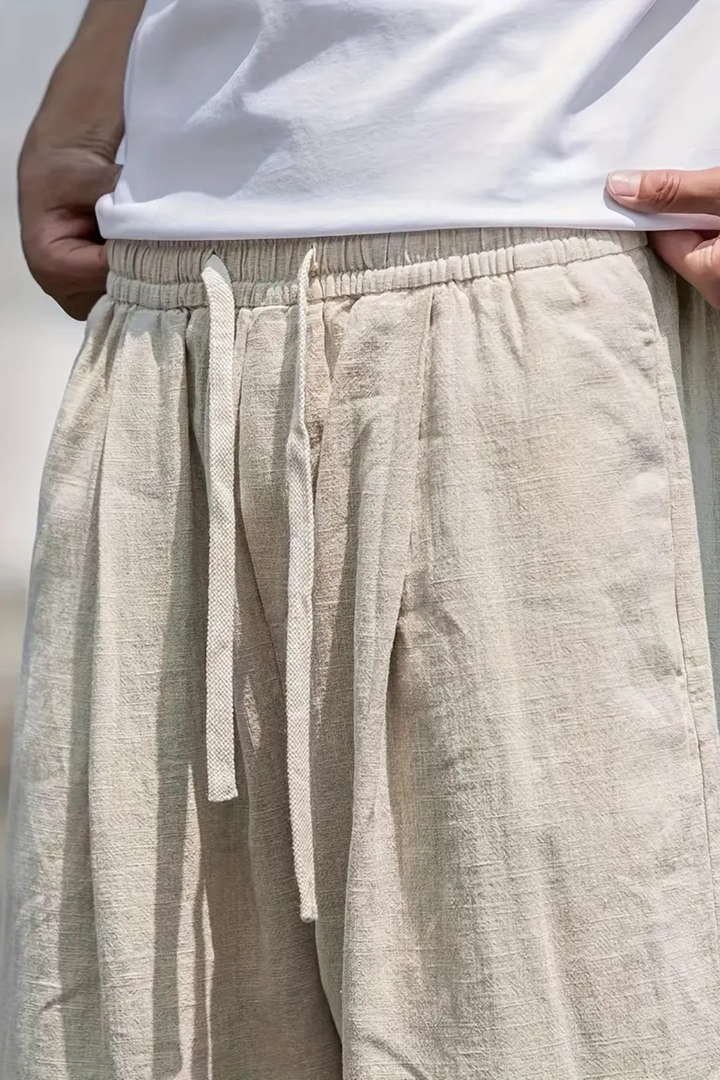 Relaxed fit men's khaki wide leg trousers with elastic waist and straight seam. Comfortable casual bottoms.