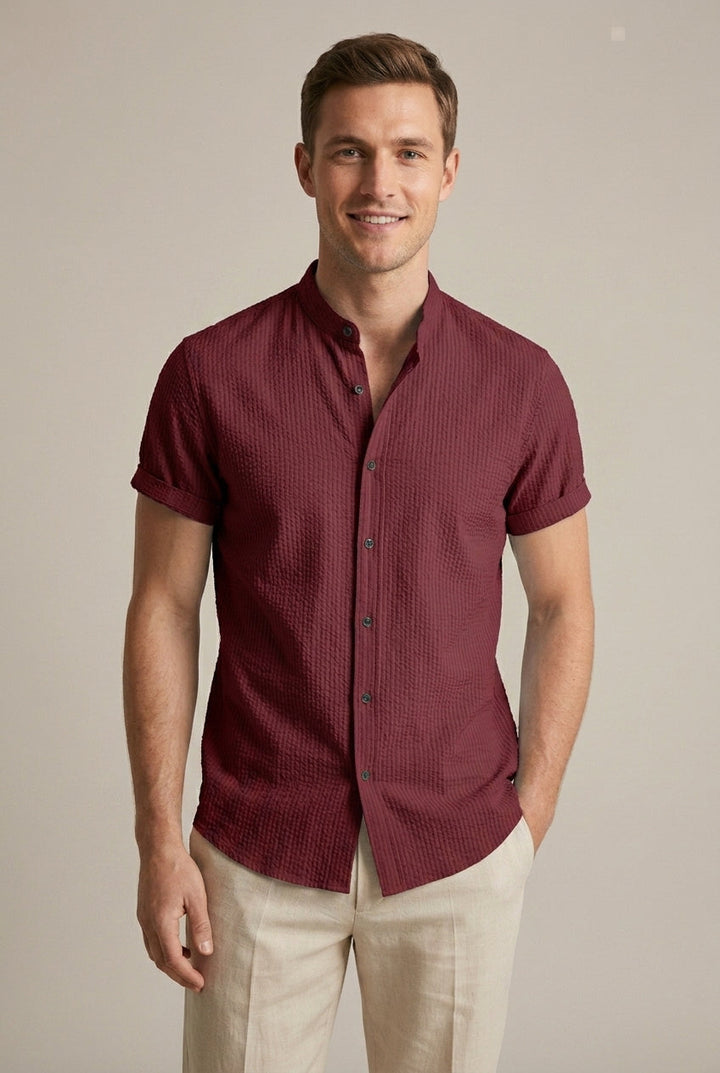 Man casually dressed in a light blue seersucker short sleeve summer shirt with a distinct band collar.