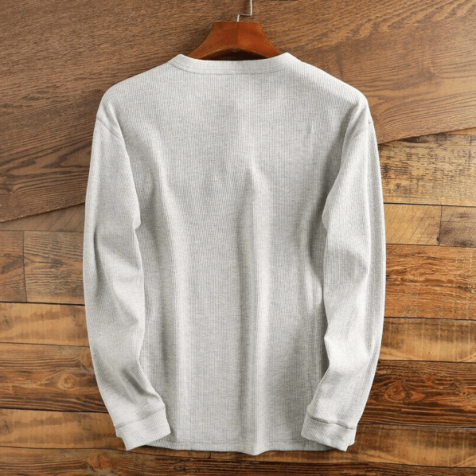 Close-up of the textured waffle knit fabric on a men's casual long sleeve henley.