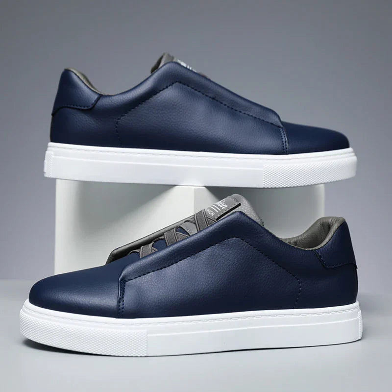 Men's modern navy blue slip-on trainers with a clean white sole.