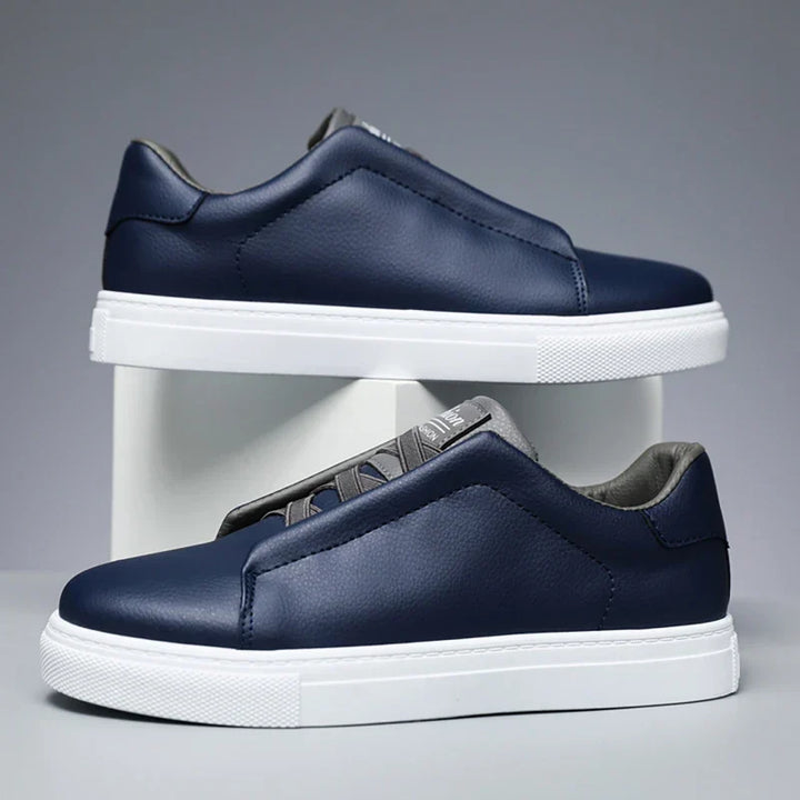 Men's modern navy blue slip-on trainers with a clean white sole.
