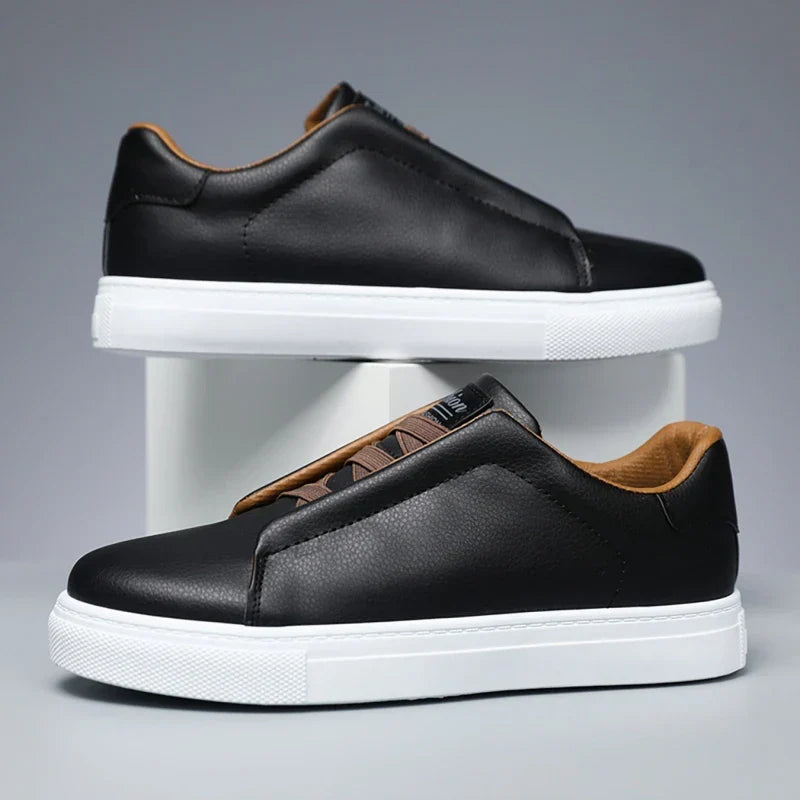 Close-up of men's casual black slip-on sneakers featuring a stylish white sole.