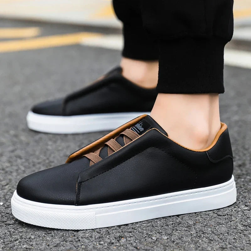 Man wearing modern navy blue slip-on trainers, highlighting the white sole design.
