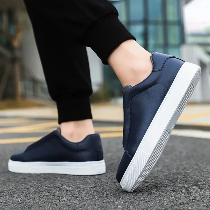Side view of men's black casual sneakers with easy slip-on design and white sole.