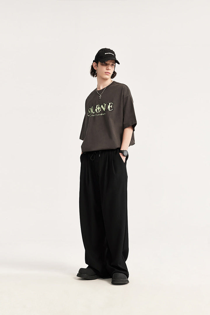Modern men's wide leg drawstring pants, pleated for a relaxed, comfortable fit. Fashionable trousers.