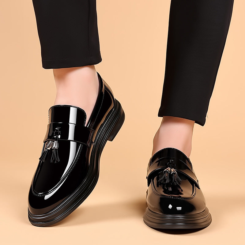 Men's polished black leather tassel penny loafers, perfect for formal or smart casual wear. Classic slip-on dress shoes.