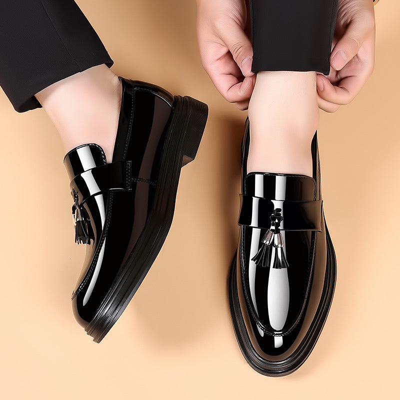 Close-up of men's elegant black leather tassel penny loafers with a polished finish, ideal for dress occasions.