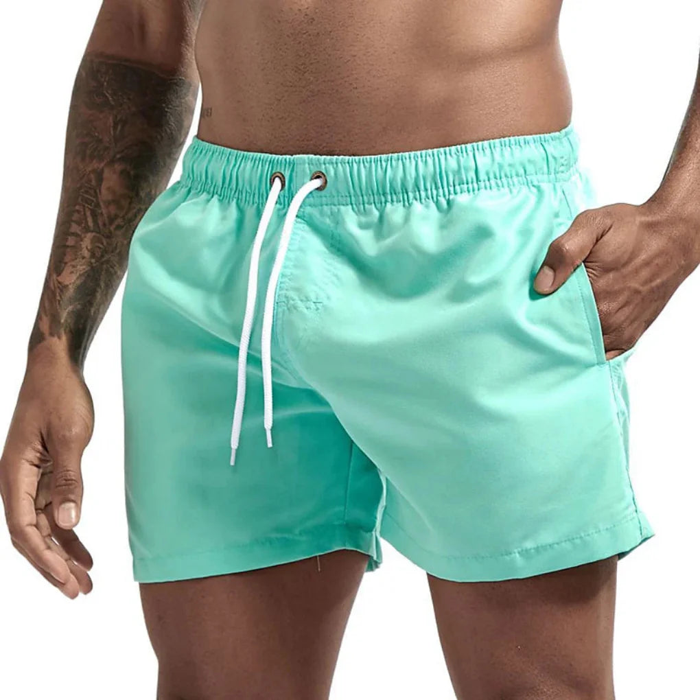 Mid-thigh men's quick-dry swim shorts, designed for beach & pool comfort.