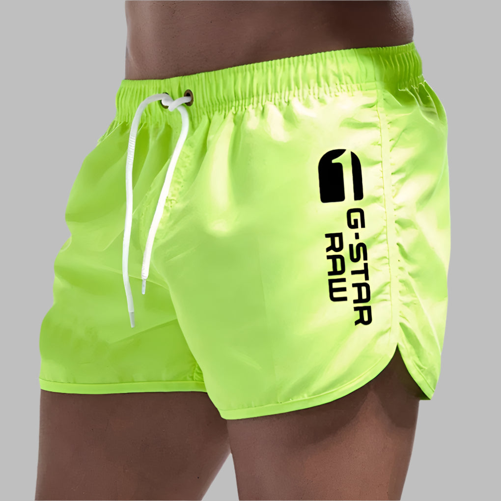 Man wearing stylish men's quick dry swim trunks at the poolside, ready for summer.