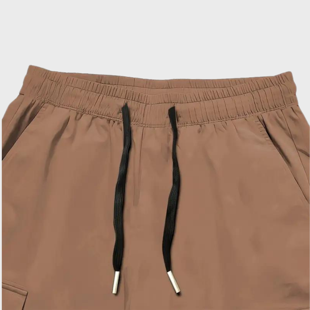 Close-up of men's brown cargo trousers showing pocket detail and relaxed fit.