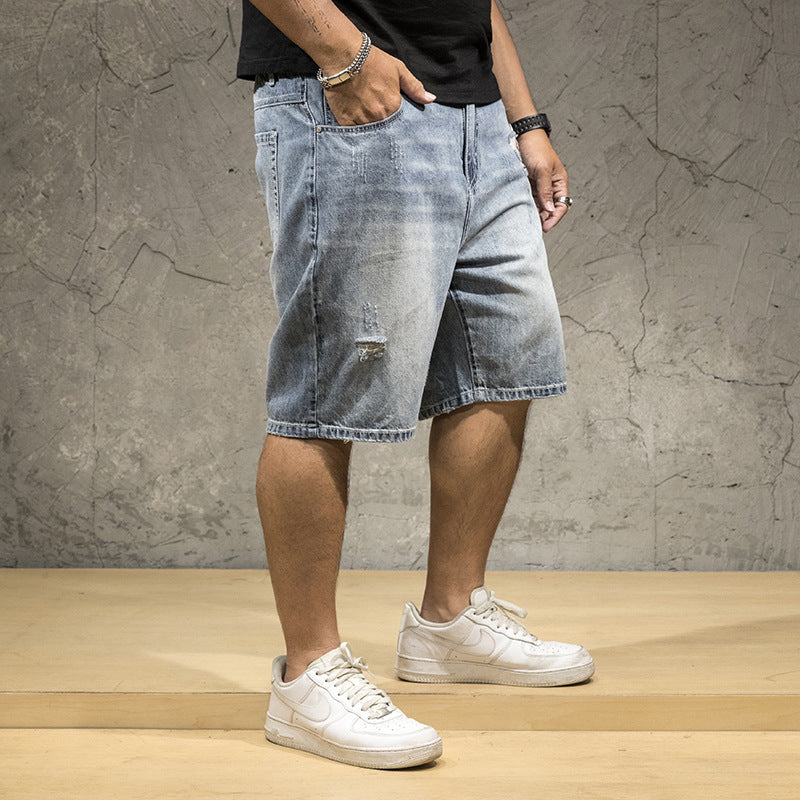 Light wash men's relaxed fit distressed shorts featuring stylish rips, perfect for a casual summer look.