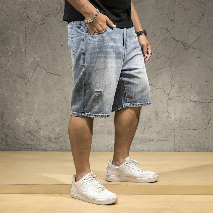 Light wash men's relaxed fit distressed shorts featuring stylish rips, perfect for a casual summer look.